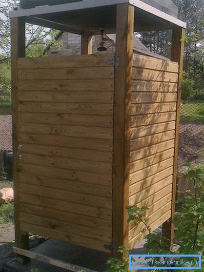 Las paredes de madera para una ducha de verano encajarán perfectamente en un paisaje campestre.