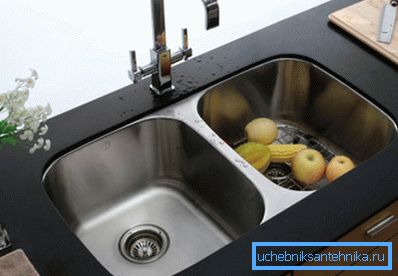 El fregadero integrado de un acero inoxidable en una mesa de una piedra artificial. El fregadero integrado de un acero inoxidable en una mesa de una piedra artificial.