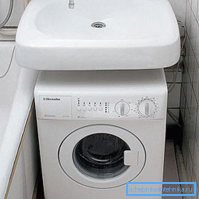 Lavadora compacta debajo del lavabo en el baño. Lavadora compacta debajo del lavabo en el baño.