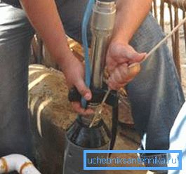 En la foto - instalación de la bomba en el pozo. En la foto - instalación de la bomba en el pozo.