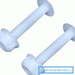 En la foto: tornillos de plástico y una tuerca para fijar el asiento del inodoro al inodoro. En la foto: tornillos de plástico y una tuerca para fijar el asiento del inodoro al inodoro.
