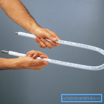 En la foto, la flexión de la tubería de metal y plástico con un resorte. En la foto, la flexión de la tubería de metal y plástico con un resorte.