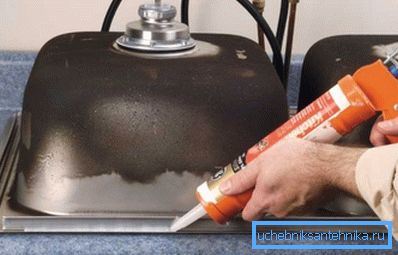 Aplicación de silicona en el interior de un fregadero de acero inoxidable antes de instalarlo en la encimera Aplicación de silicona en el interior de un fregadero de acero inoxidable antes de instalarlo en la encimera