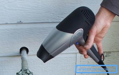 Calentando la tubería de agua fría con un secador industrial. Calentando la tubería de agua fría con un secador industrial.