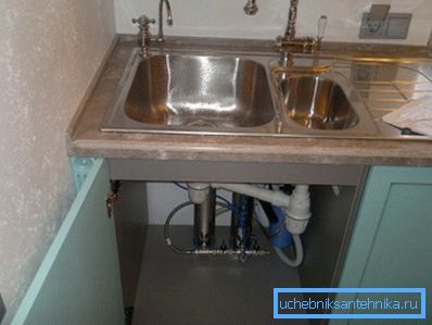 Instalación de filtro doméstico en la mesita de noche debajo del fregadero.